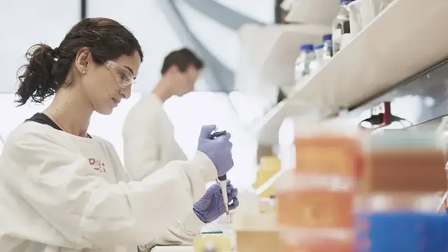 An anaesthetist researcher in a laboratory carefully pipetting a sample, representing the VAPOR-C trial's focus on precision in clinical research.