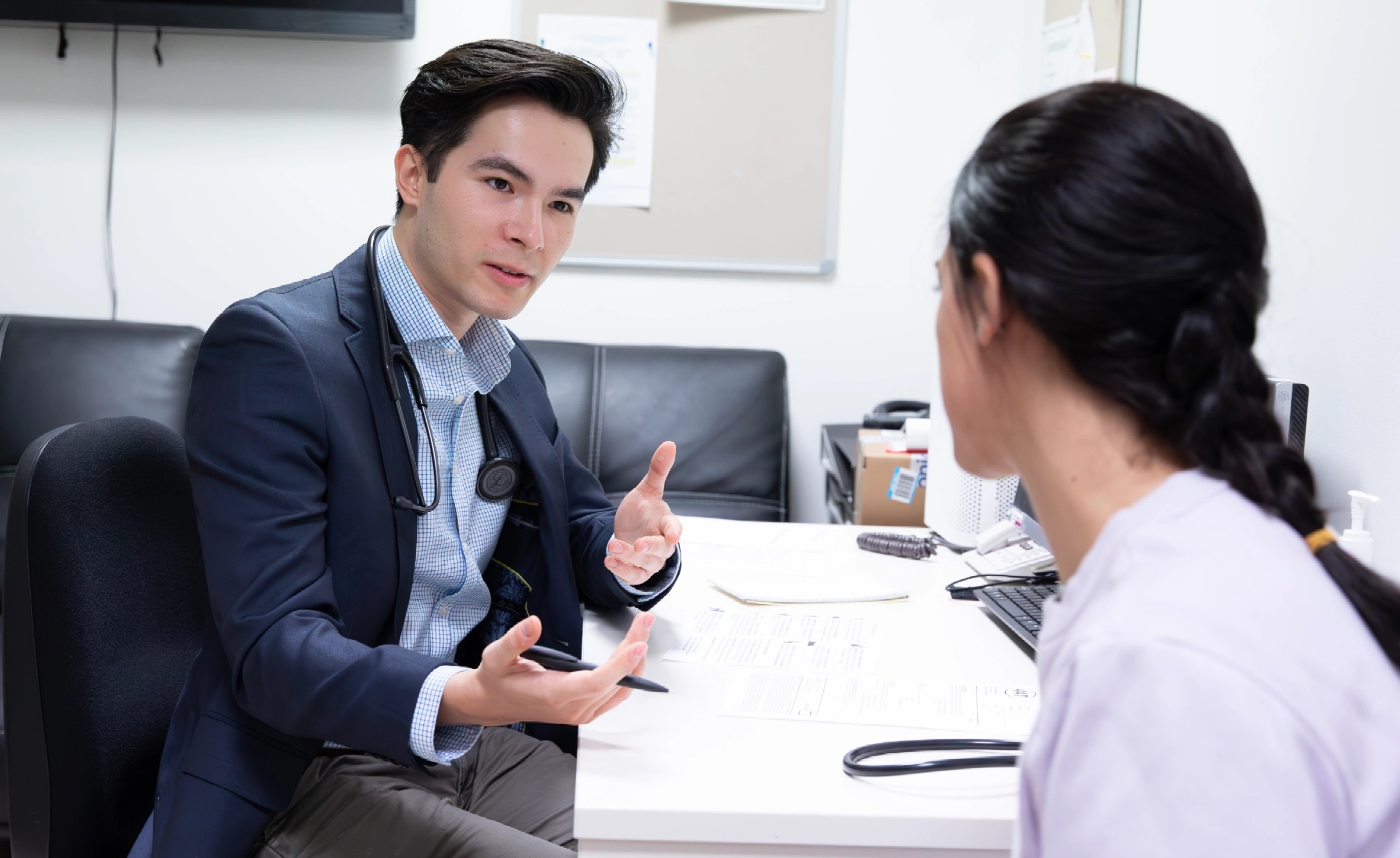 Doctor talking to patient in consulting room