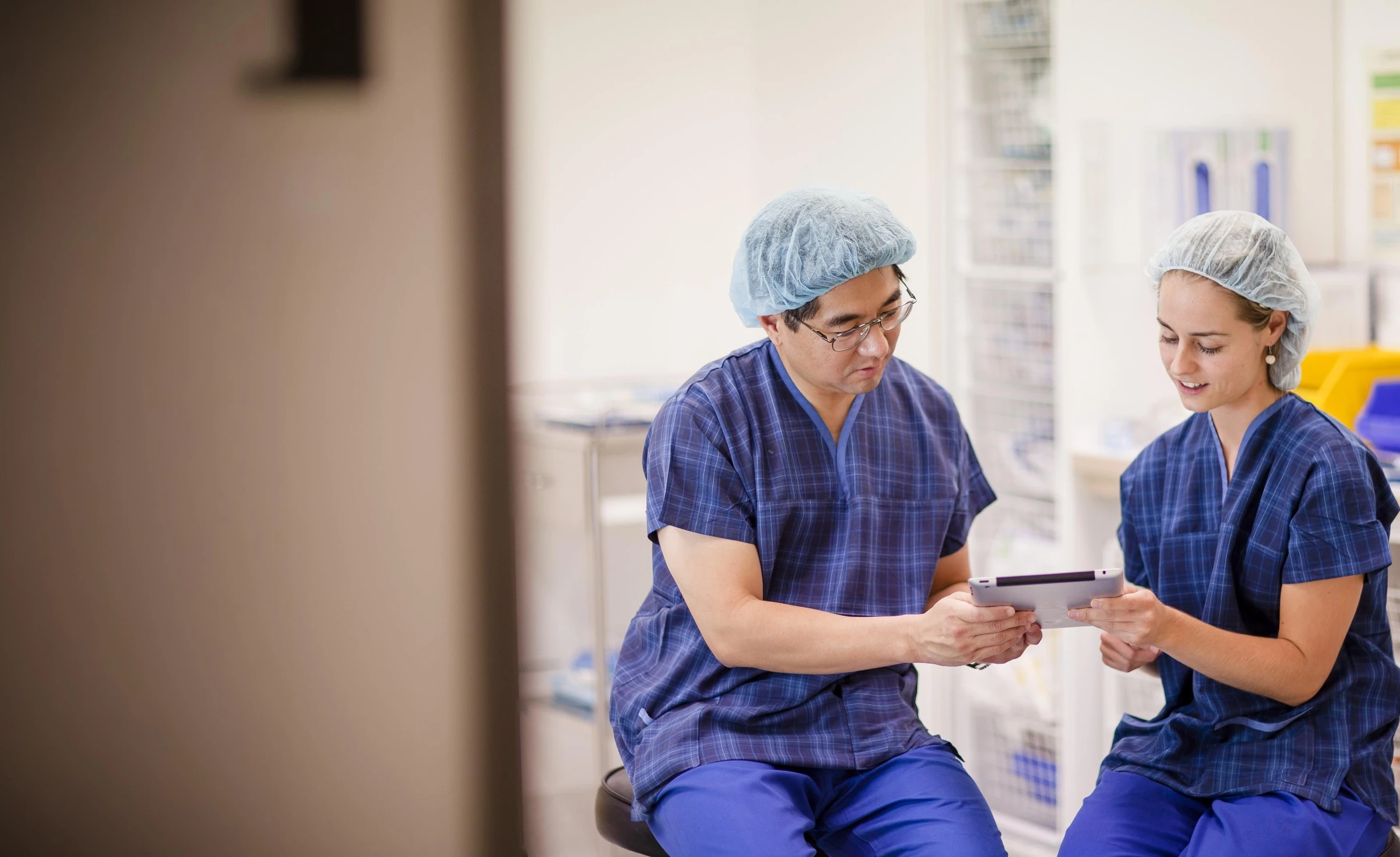 Photo of two doctors sitting together reading a document