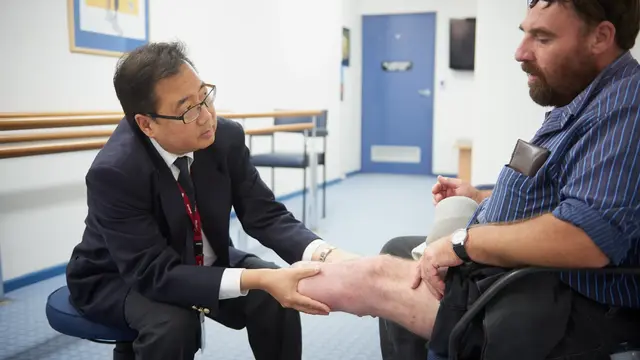Male doctor reviews an amputee patient