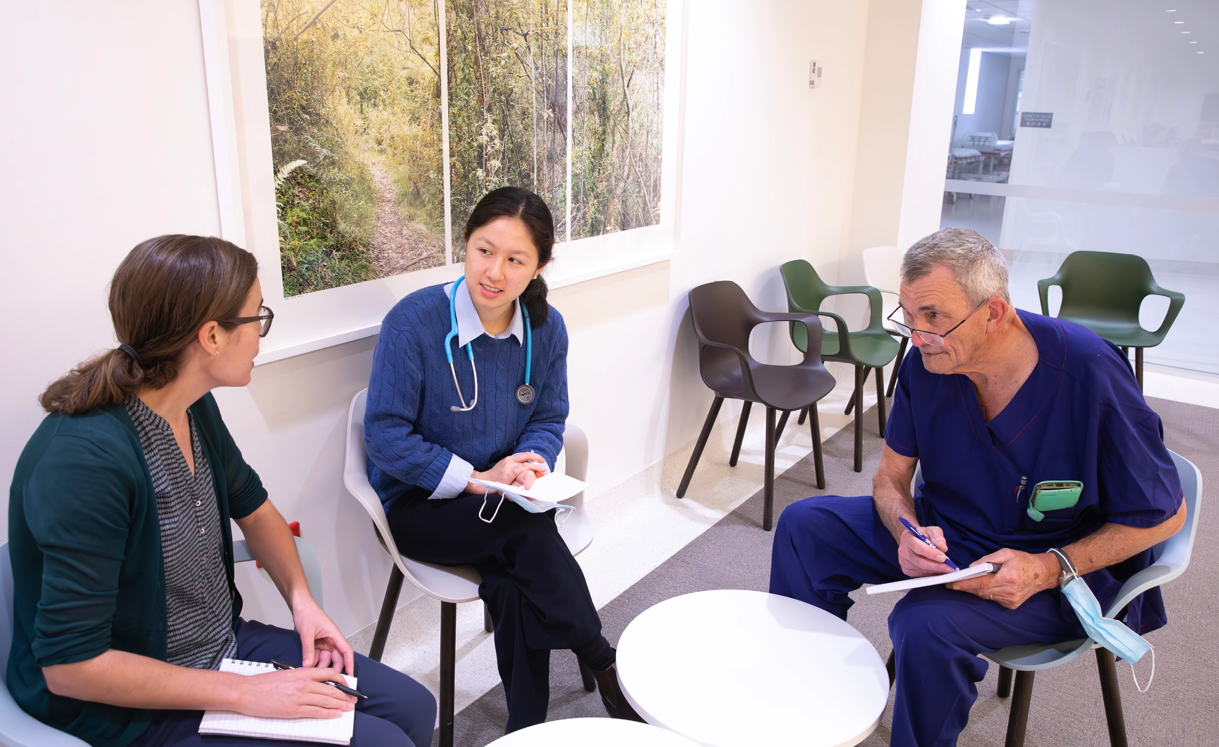 Doctors talking to each other with notepads