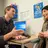 Patient and doctor in consulting room talking to each other in front of computer