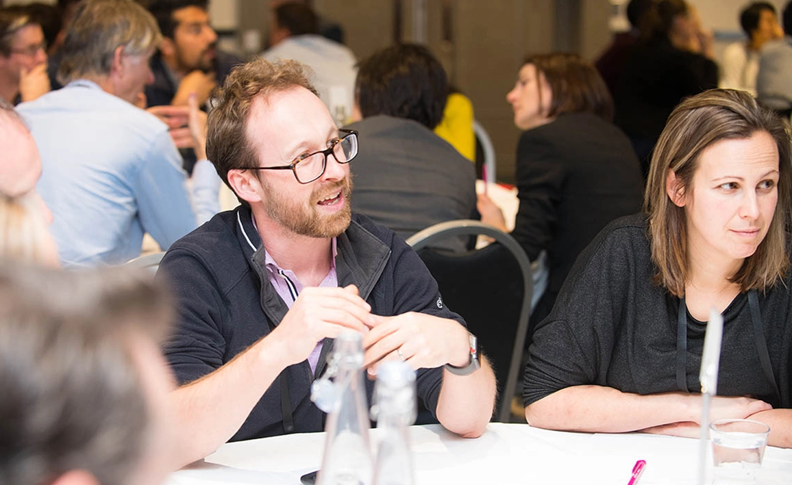 A group of professionals engaged in a discussion at a round table.