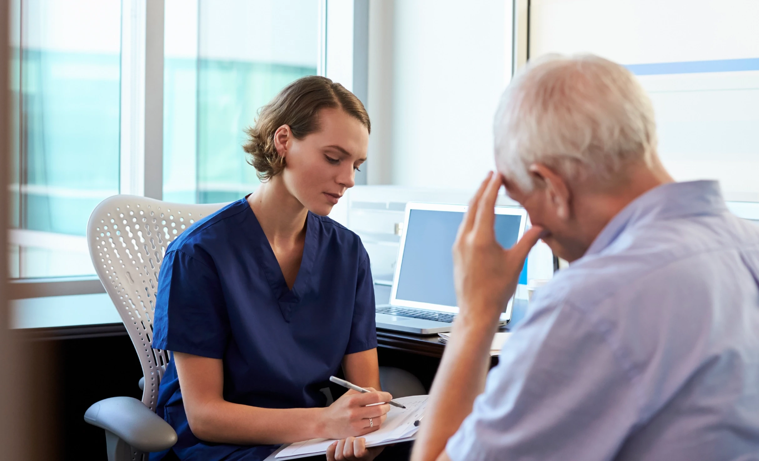 A female doctor discusses pain options with an older man