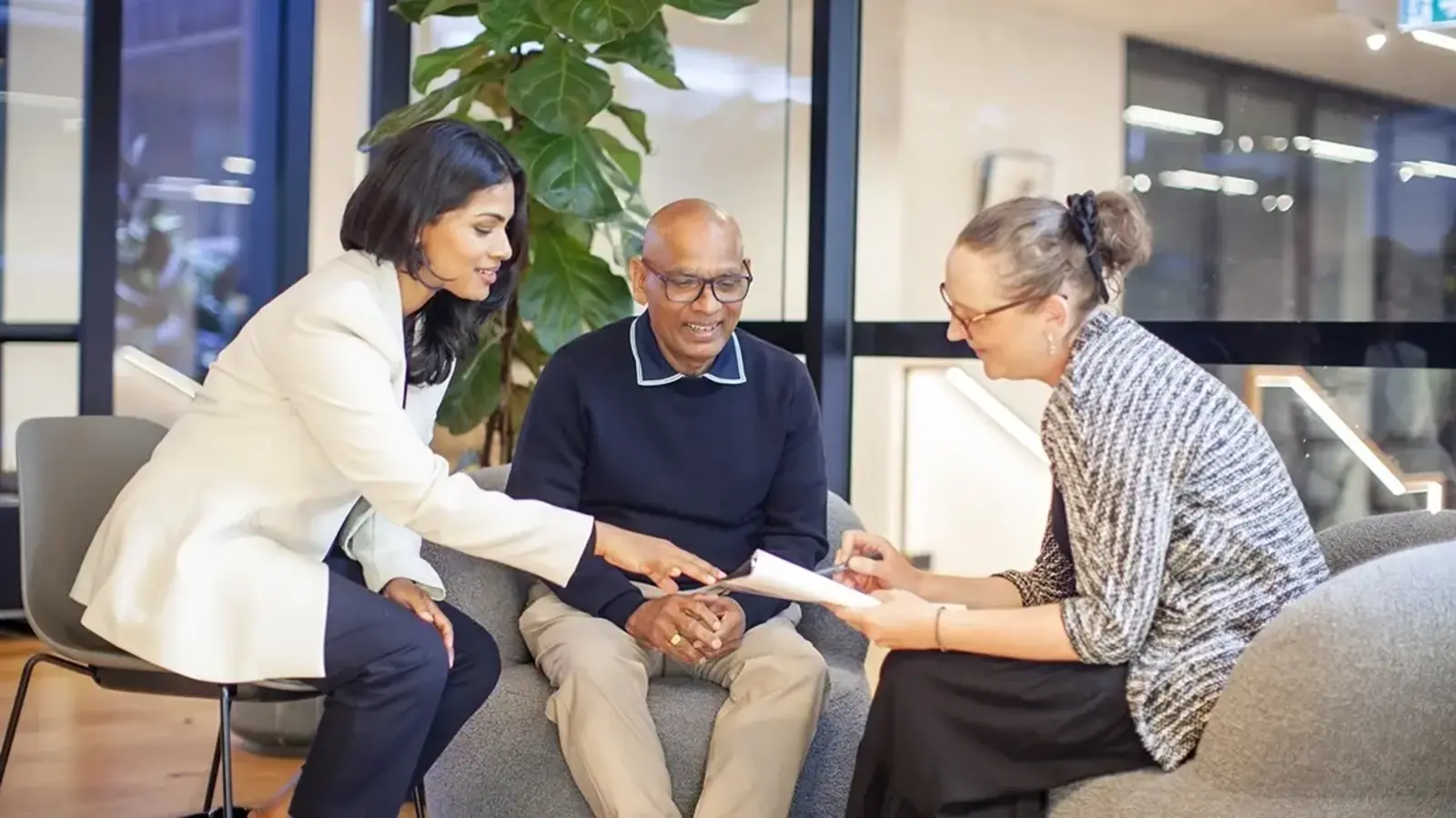 A patient and their carer discussing a clinical trial with a research coordinator.
